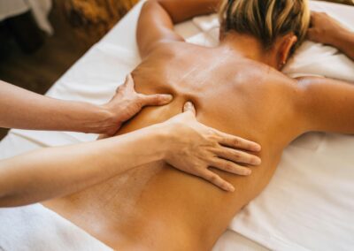 Close-up of a relaxing massage therapy session at a spa with focus on back and hands.